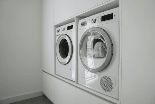 Witte bijkeukenkast met wasmachine en droger op hoogte
