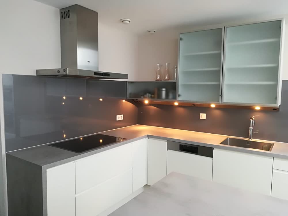 Witte keuken met houten schap en zwarte achterwand