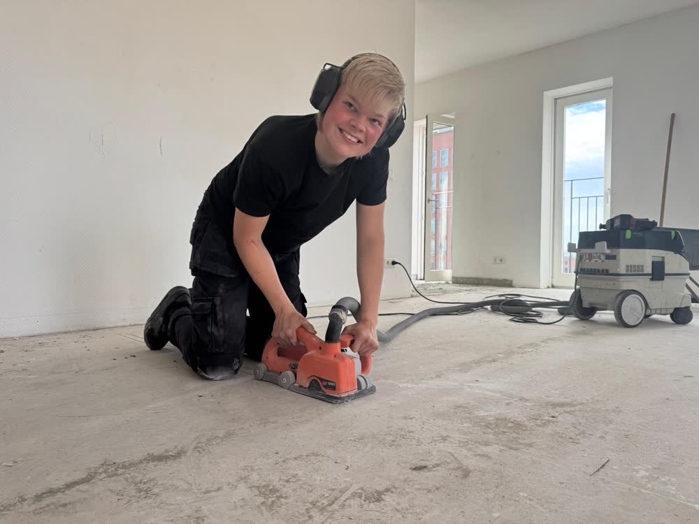 De vloer wordt geschuurd voordat de nieuwe vloer erop gaat