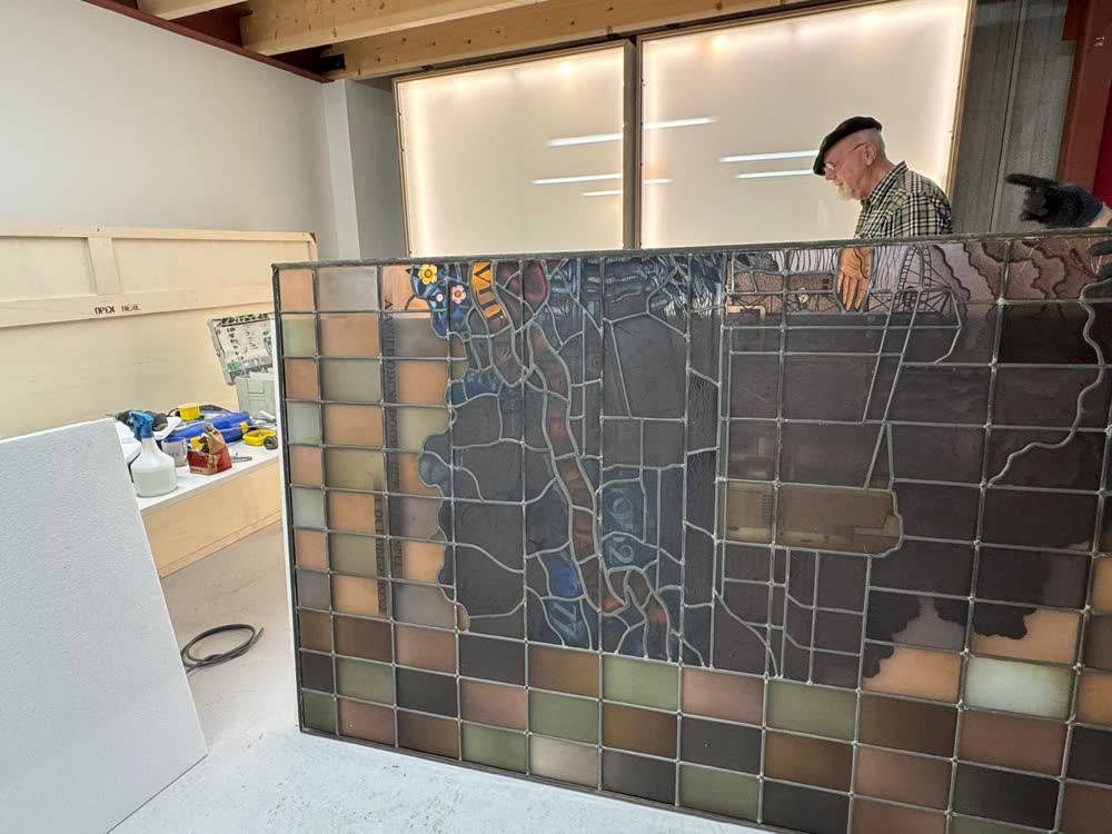 Een glas-in-loodpaneel wordt in onze werkplaats in een kast gezet