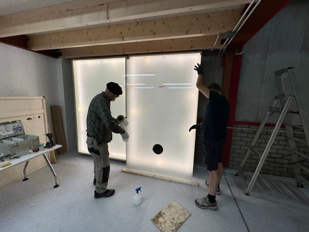 Twee vakmensen zetten een verlicht paneel in de werkplaats
